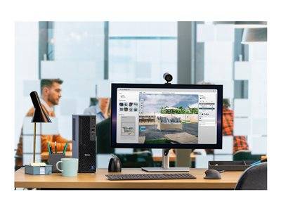 Ein moderner Bürotisch mit einem Computer, auf dem Architekturdesign-Software angezeigt wird, inmitten einer Büroumgebung mit Glassswänden.