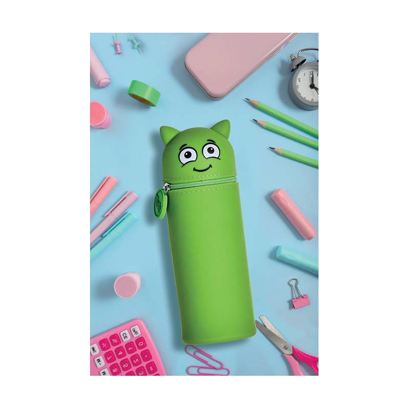 Eine grüne Federmappe in Katzenform ist von Schreibutensilien umgeben, darunter Bleistifte, ein Taschenrechner, Schere und eine Uhr.