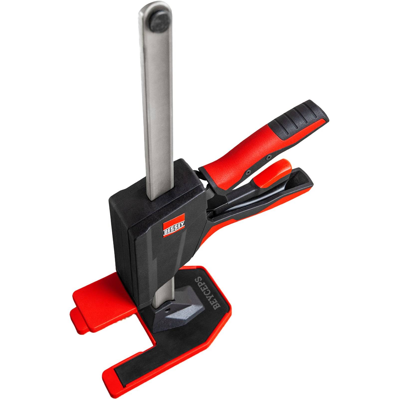 Eine rote und schwarze Bessey-Zwinge mit einer langen Metallstange und ergonomischem Griff, die zum Befestigen von Materialien in der Holzverarbeitung oder im Baugewerbe verwendet wird.