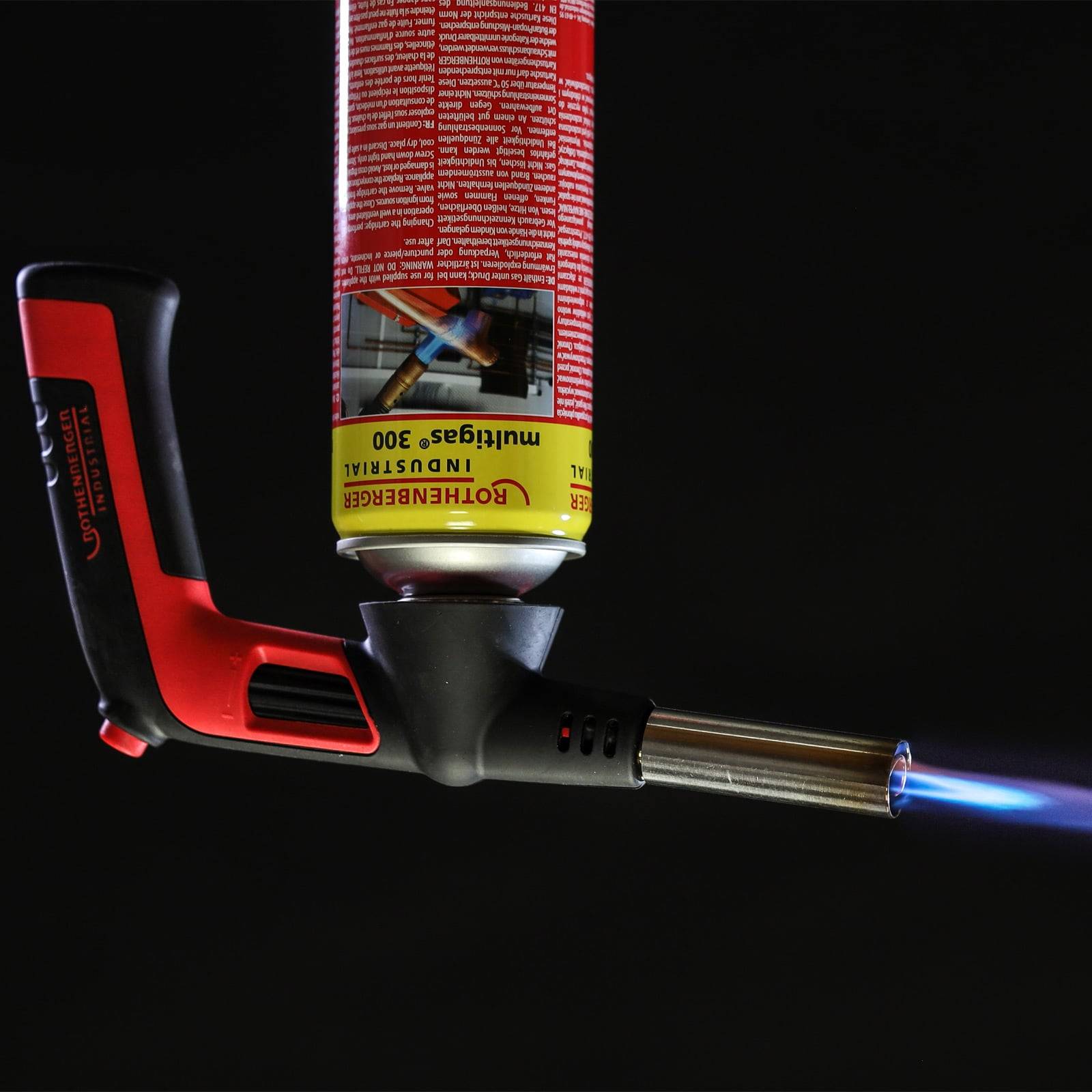 Eine Handfackel mit einer sichtbaren Flamme, die vor einem schwarzen Hintergrund gehalten wird.