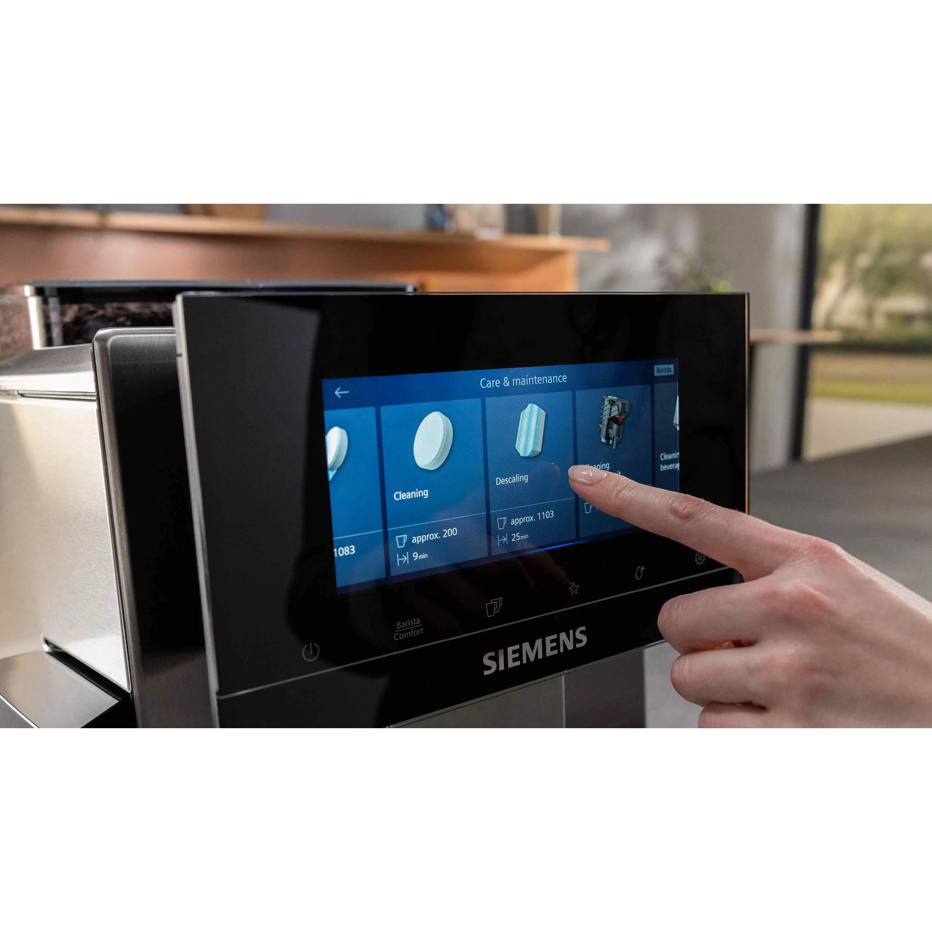 Hand tippt auf den Touchscreen eines Siemens-Geräts im Menü „Pflege & Wartung