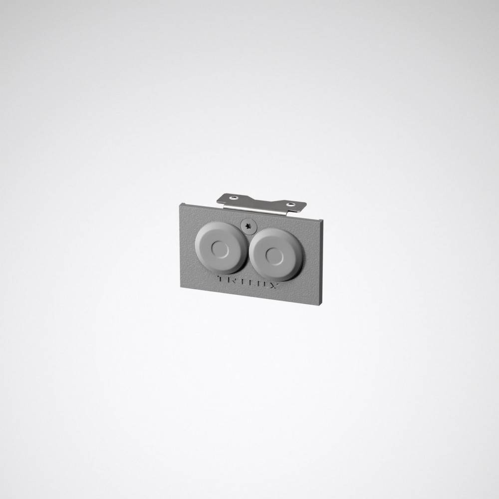 Eine rechteckige Platte mit zwei runden Schaltern und Braille-Schrift, die für die elektrische Steuerung verwendet wird, vor einem einfarbigen Hintergrund.