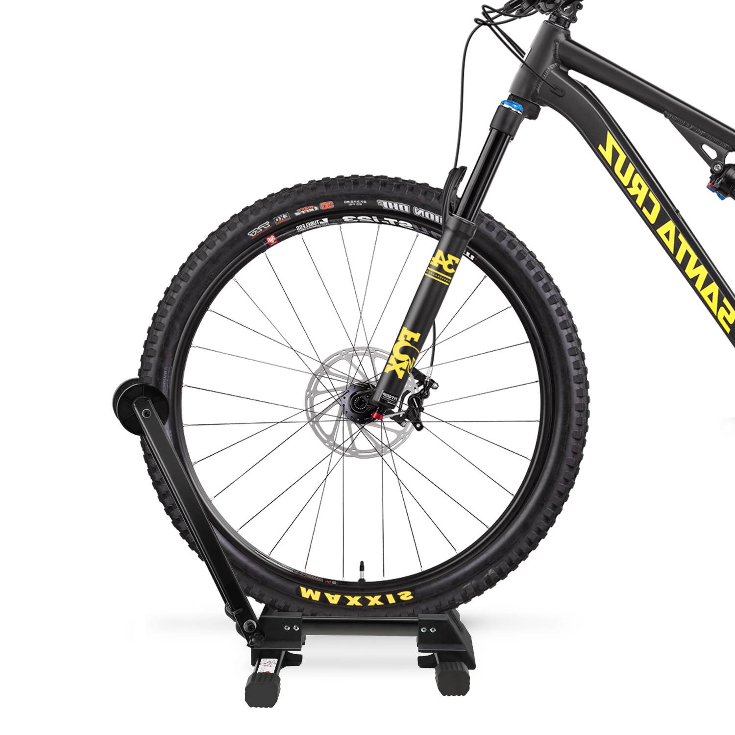 Vorderrad eines schwarzen Mountainbikes, das auf einem Trainingsständer montiert ist, wobigt die Gabel, die Scheibenbremse und den Stollenreifen auf weißem Hintergrund zeigt.