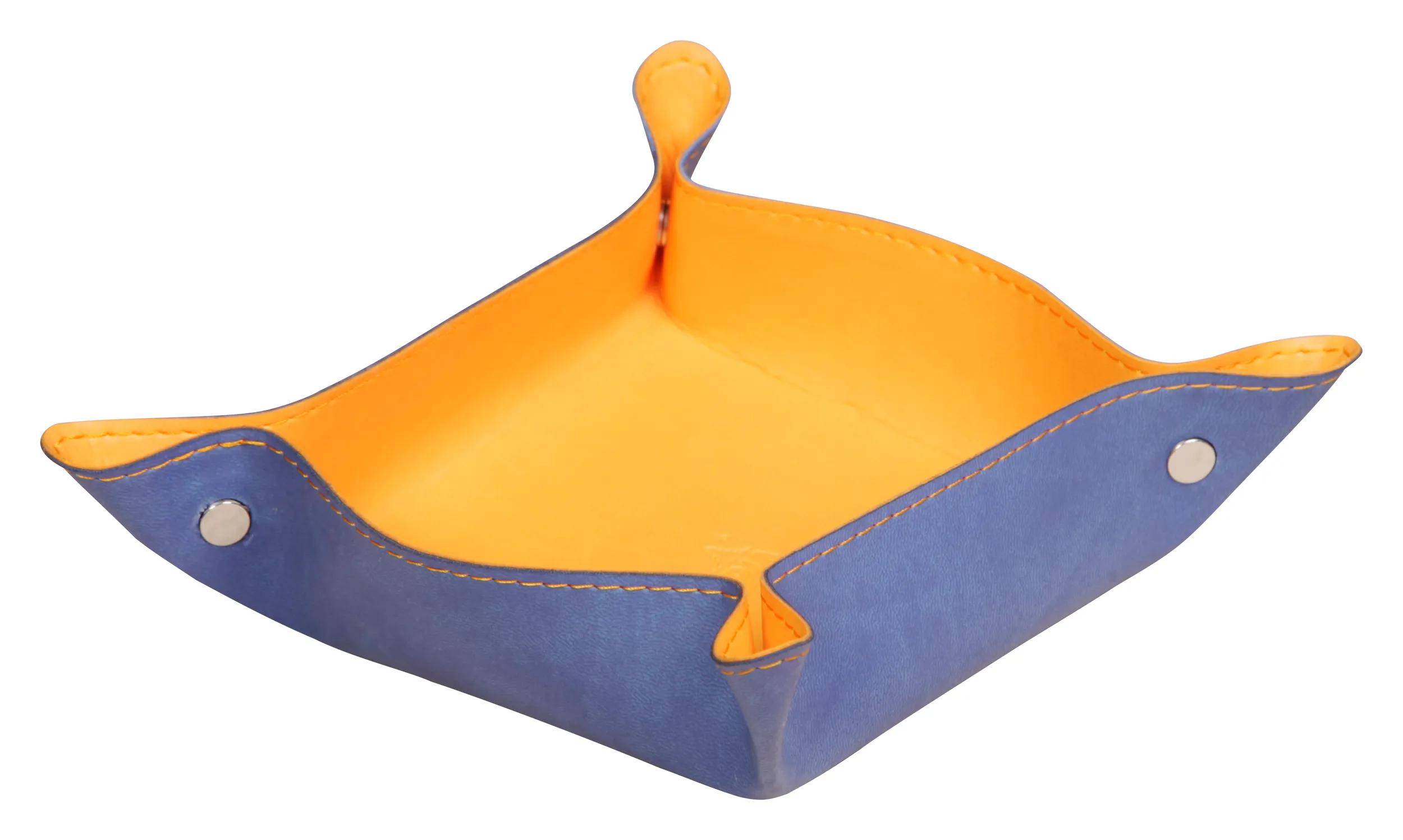 Ein blau und orange farbenes Lederkörbchen mit erhöhten Ecken, das zur Aufbewahrung kleiner Gegenstände wie Schlüssel, Münzen und Schmuck verwendet wird.