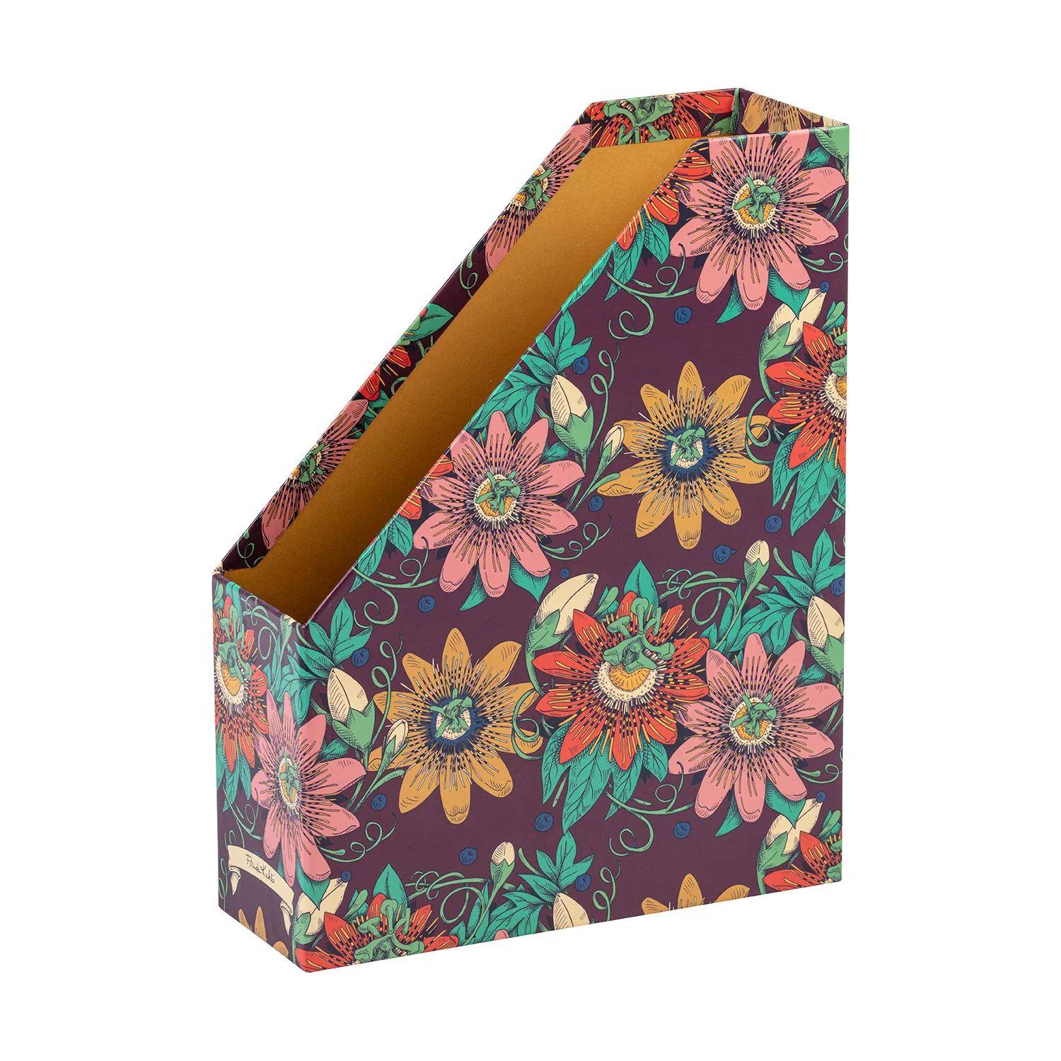 Ein Zeitschriftensammler mit Blumenmuster, der bunte Blumen und Blätter auf einem dunklen Hintergrund zeigt und zur Organisation von Dokumenten oder Zeitschriften verwendet wird.