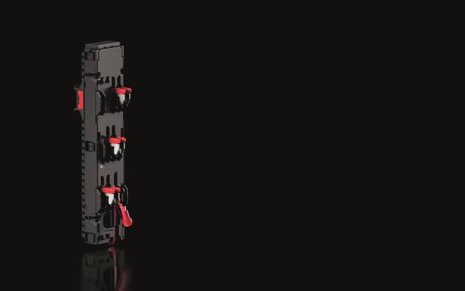 Ein schwarzer elektrischer Anschlussblock mit mehreren roten Schaltern, die vertikal ausgerichtet sind, vor einem durchgehend schwarzen Hintergrund.