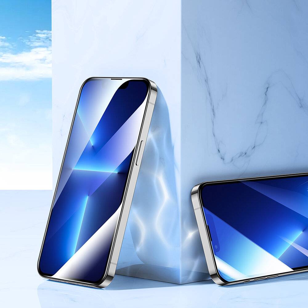 Zwei Smartphones mit blau gestalteten Bildschirmen sind auf einer reflektierenden Oberfläche unter heller Beleuchtung angeordnet. Eines steht aufrecht und das andere ist angewinkelt.