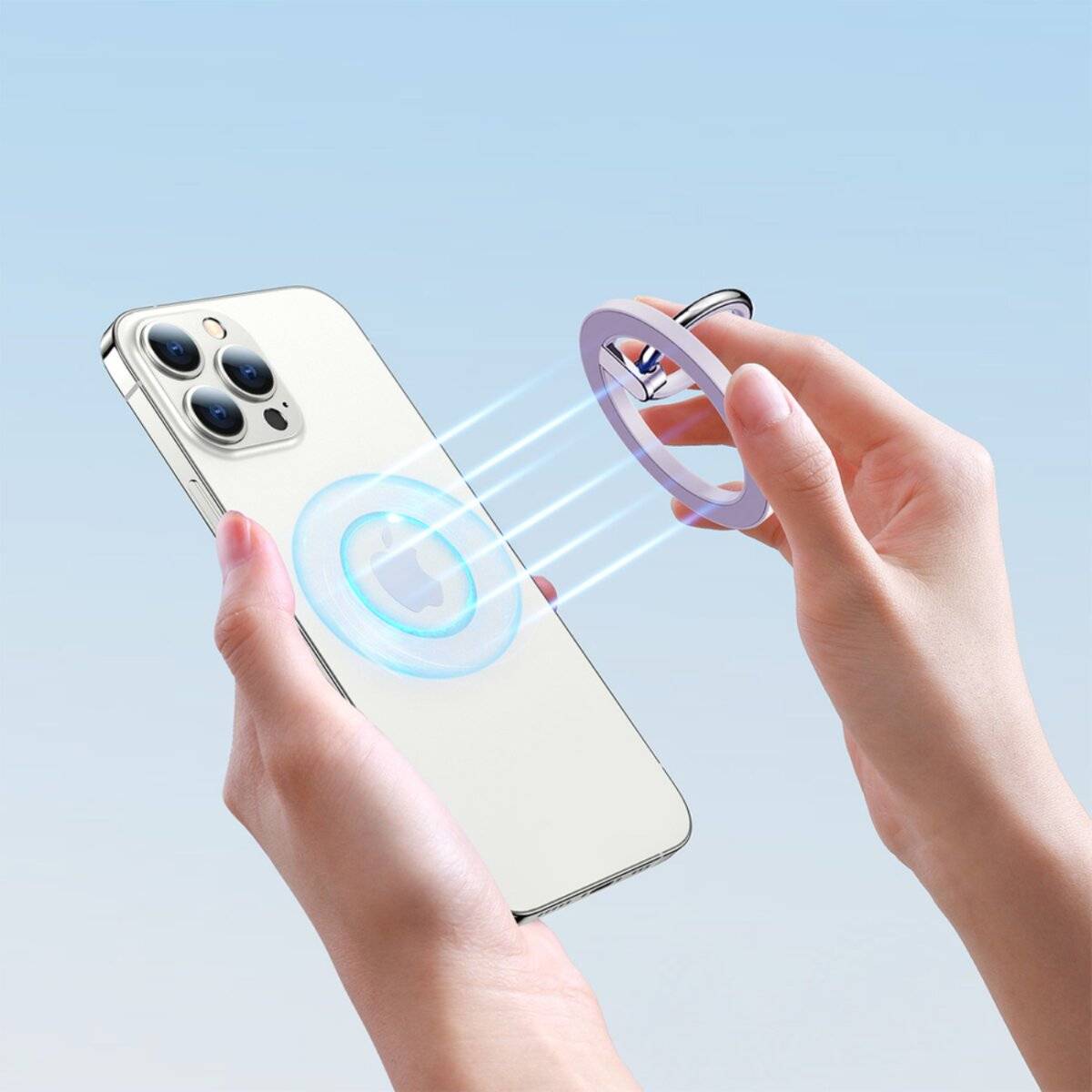 Eine Person hält ein Smartphone mit einem magnetisch befestigten Ring an der Rückseite und demonstriert die Drahtlos-Ladefähigkeit vor einem blauen Hintergrund.