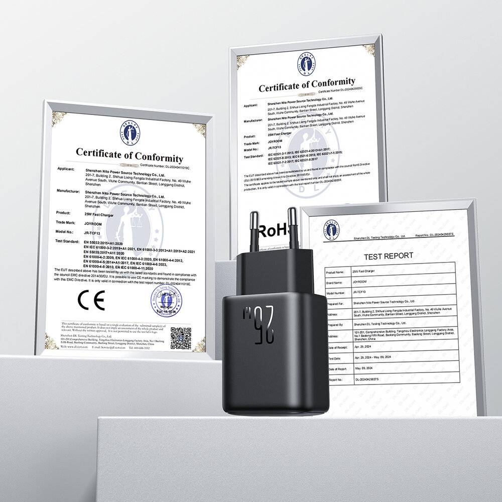 Ein schwarzer Stecker sitzt vor gerahmten Zertifikaten, die Konformität und Testberichte anzeigen und die Einhaltung von Sicherheitsstandards hervorheben.