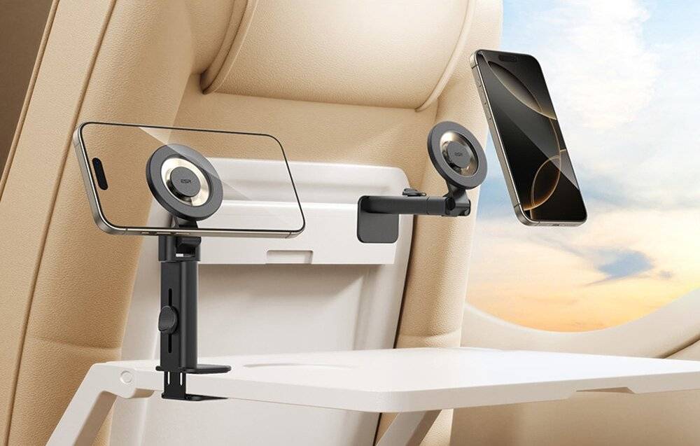 Telefonhalterung auf einem Flugzeugtablett montiert, die ein Smartphone hält. Die Anordnung ermöglicht die freihändige Nutzung während der Reise.