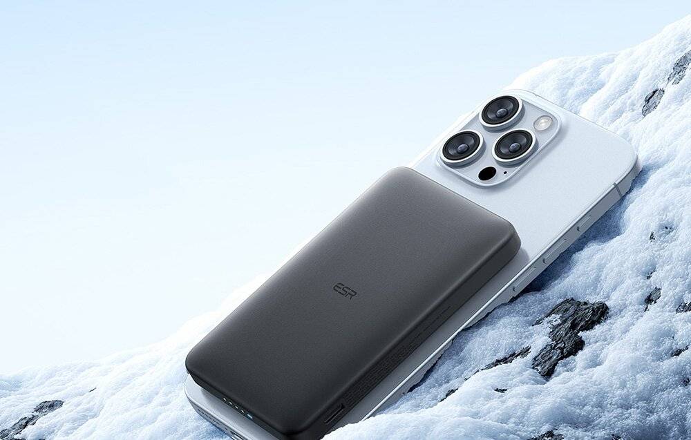 Ein schlankes, schwarzes Powerbank ruht auf einem silbernen Smartphone mit Triple-Lens-Kamera und zeigt eine tragbare Ladelösung.