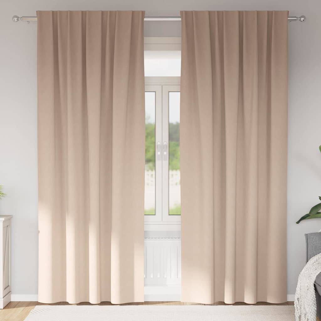 Beige Vorhänge sind über einem Fenster geschlossen, während weiches natürliches Licht hindurchfiltert und eine gemütliche und friedvolle Atmosphäre im Raum erzeugt.
