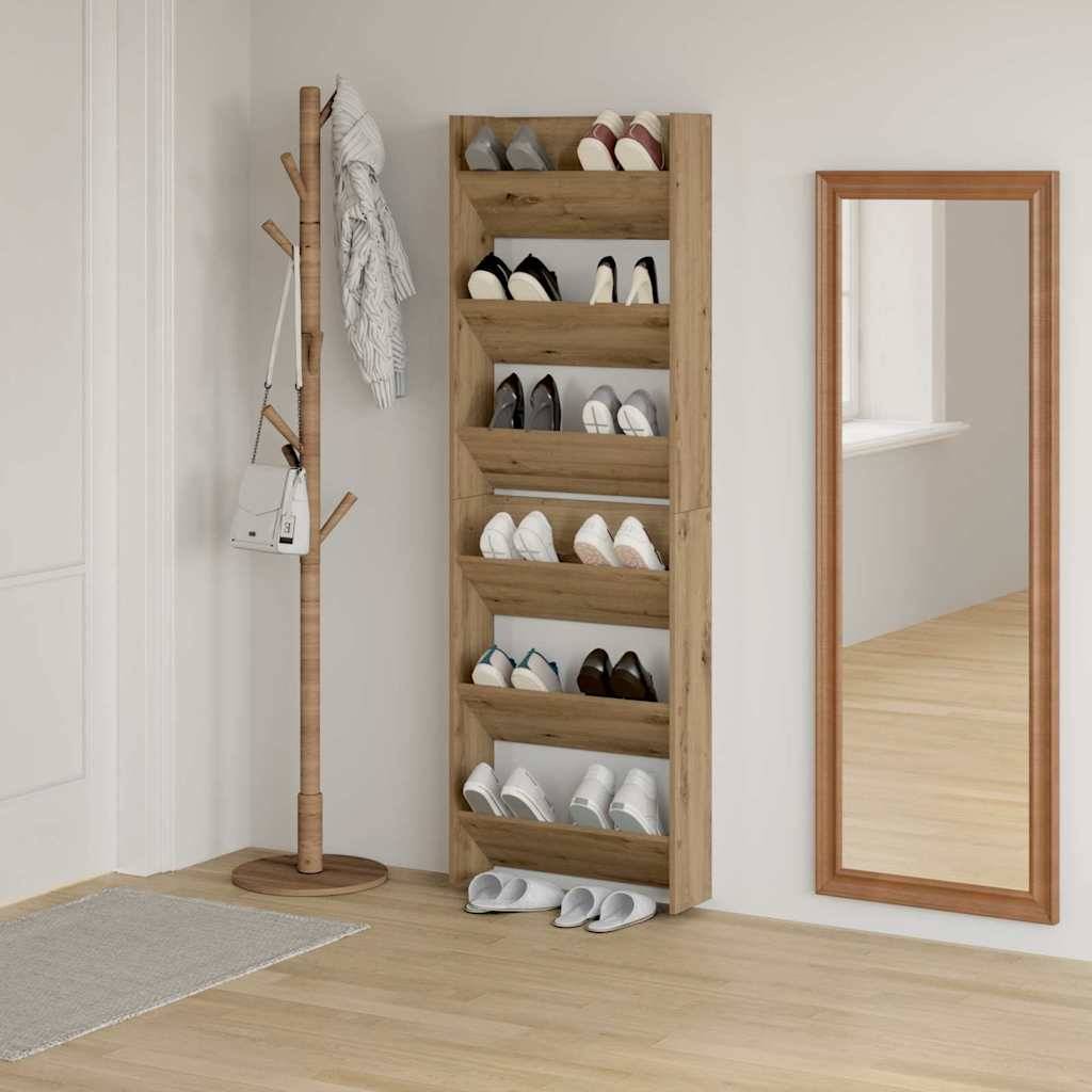 Ein Schuhschrank aus Holz an der Wand, der 15 Paare Schuhe aufnimmt. In der Nähe ein Garderobenständer mit einer weißen Tasche und ein Ganzkörperspiegel, die den minimalistischen Raum reflektieren.