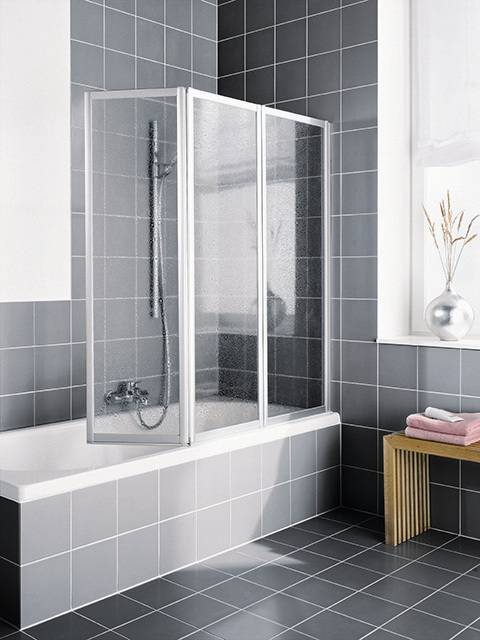 Modernes Badezimmer mit einer Glasduschkabine über einer Badewanne, dunkelgrauen gekachelten Wänden und Boden sowie einer kleinen Bank am Fenster.
