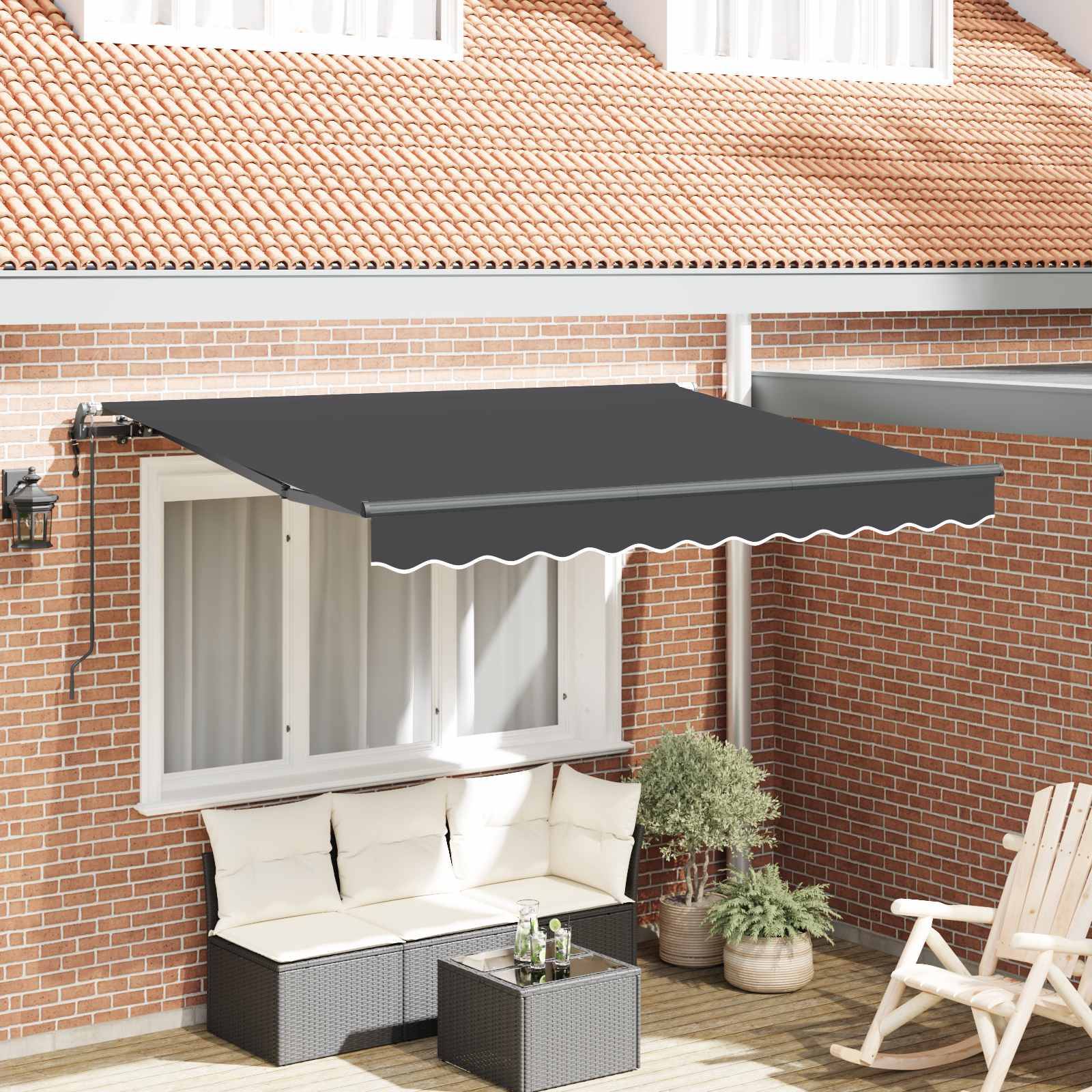 Ein Haus mit einem roten Ziegeldach hat ein ausgedehntes graues Vordach über einer Terrasse. Darunter befindet sich ein Korbsofa mit weißen Kissen und einem kleinen Tisch.