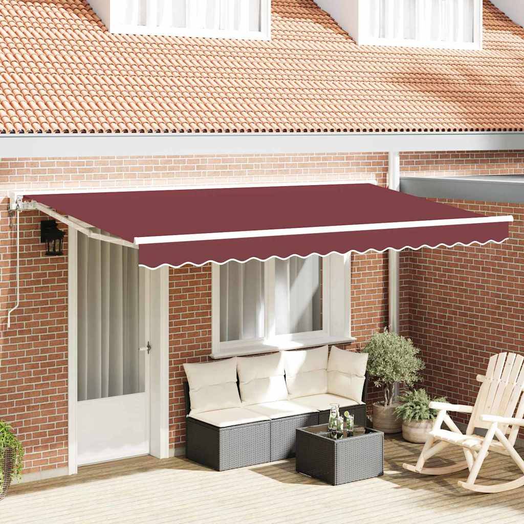 Eine rote ausfahrbare Markise erstreckt sich über einen gemütlichen Patiobereich mit einer weißen Tür, einem beigen Outdoor-Sofa, Topfpflanzen und einem Holzstuhl.