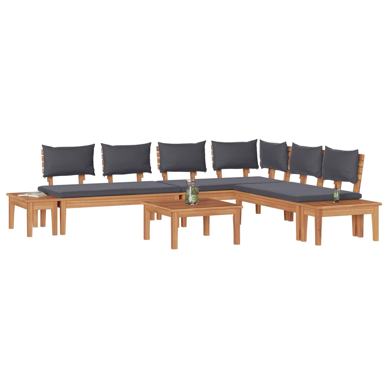 Holz-Ecksofa mit dunklen Kissen in L-Form, ausgestattet mit einem kleinen passenden Beistelltisch und einem Couchtisch, auf denen jeweils eine Flasche steht.