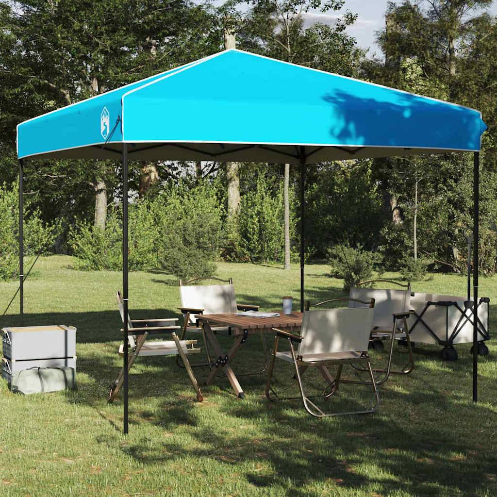 Ein blauer Pavillon ist auf einer Rasenfläche aufgestellt, mit mehreren Klappstühlen und einem Tisch darunter, umgeben von Bäumen und Büschen.