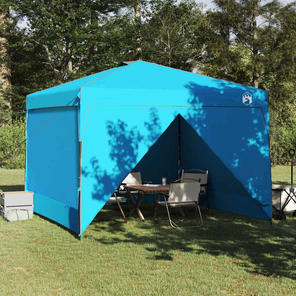 Ein blaues Pavillon-Zelt auf Gras aufgebaut, mit Campingstühlen und einem Tisch darunter, umgeben von Bäumen und einigen Lagerboxen in der Nähe.