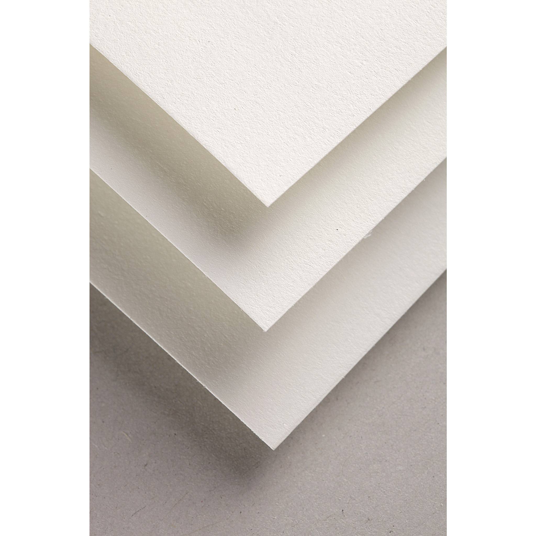Nahaufnahme von geschichteten, cremefarbenen Papierschichten, die eine V-förmige Ecke auf einer hellgrauen Oberfläche bilden.