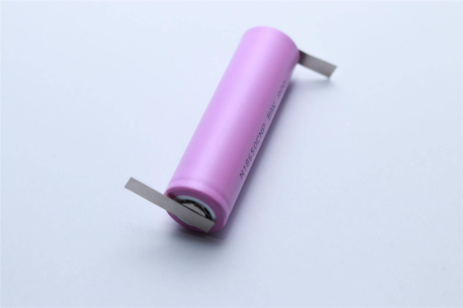 Eine rosa zylindrische Batterie mit Metallanschlüssen an beiden Enden, die häufig in elektronischen Geräten verwendet wird.