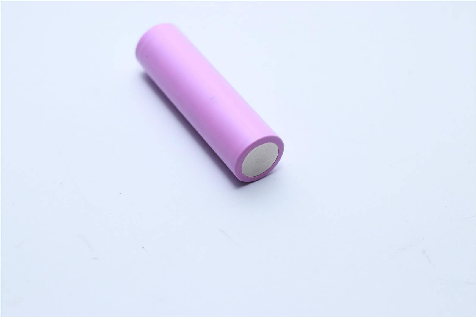 Eine einzelne rosa Zylinderbatterie liegt auf einem weißen Hintergrund.
