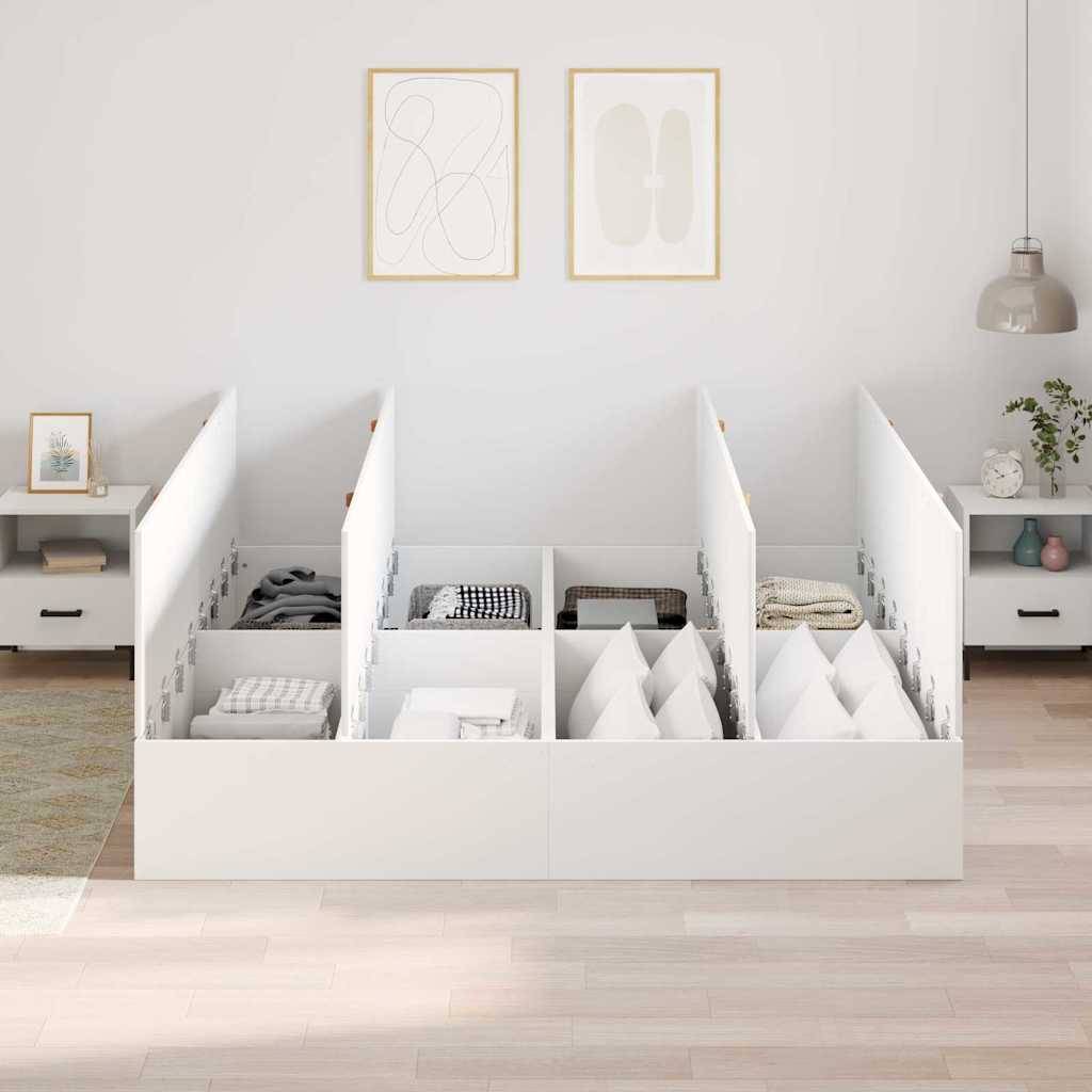 Weißes Speicherbett mit offenen Fachabteilungsunterteiler, das zusammengelegte Kleidung, Kissen und Bettwäsche in einem minimalistischen Schlafzimmer enthält.