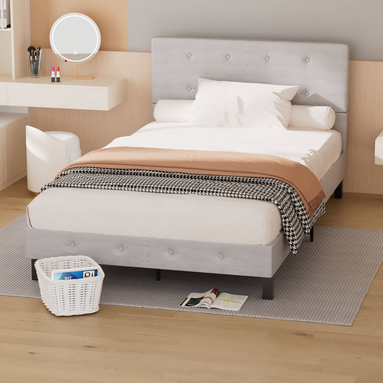 Modernes Schlafzimmer mit einem grau gepolsterten Bett, weißer Bettwäsche, Schreibtisch und rundem Spiegel, plus einem Korb und aufgeschlagenem Magazin auf dem Boden.