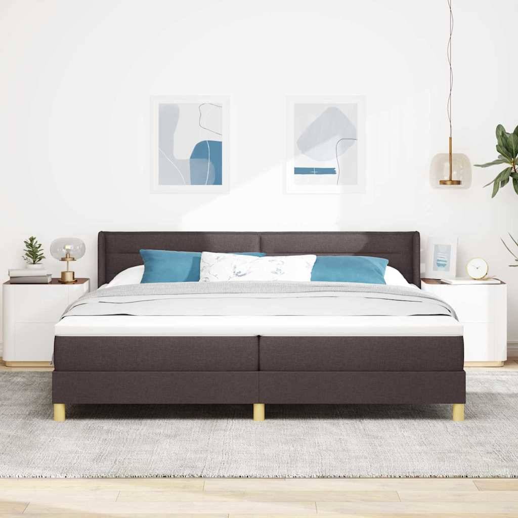 Modernes Schlafzimmer mit einem dunkel gepolsterten Bett, weißer Bettwäsche und blauen Kissen, flankiert von weißen Nachttischen unter minimalistischer Wandkunst.