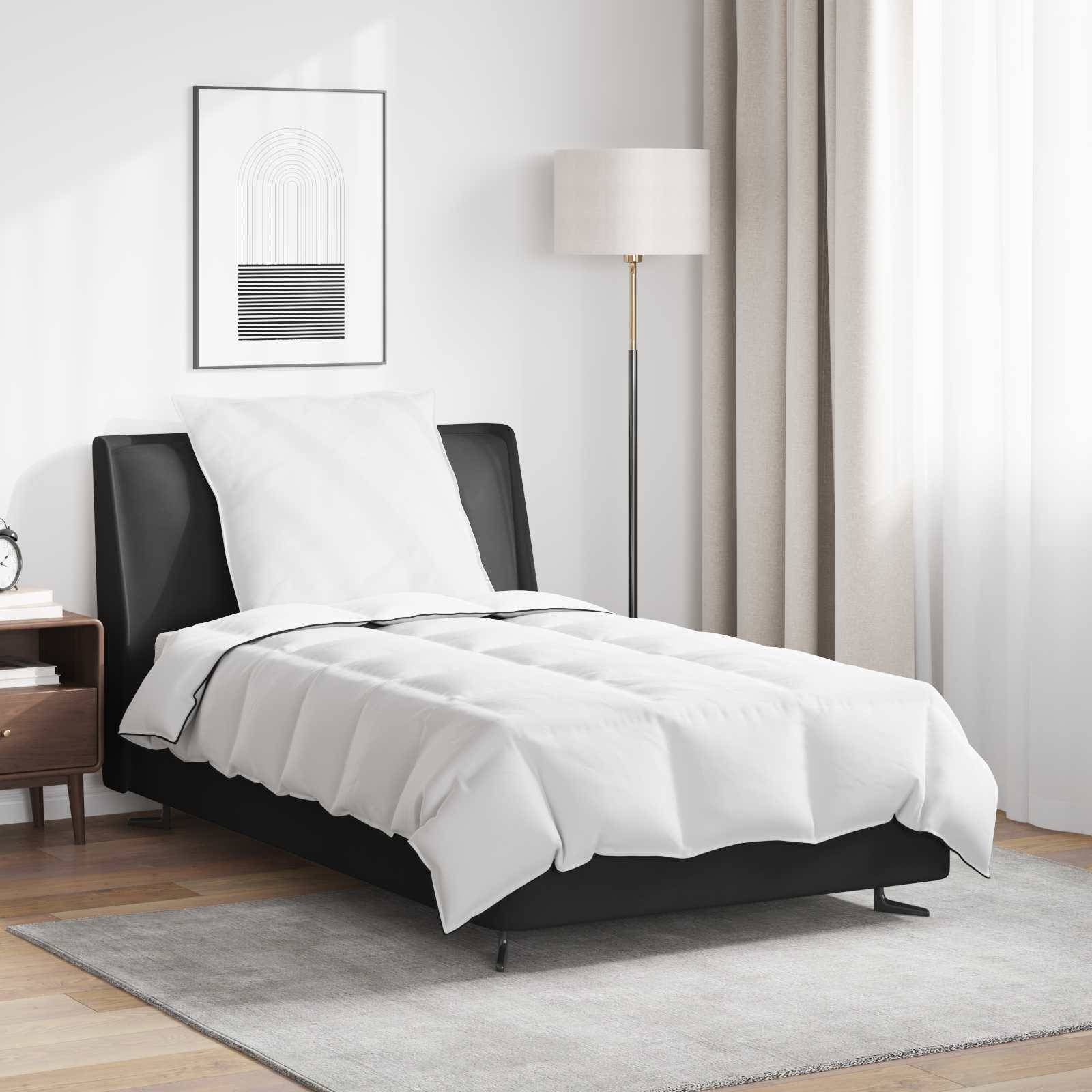 Ein modernes Schlafzimmer mit einem schwarzen Bett, weißer Bettwäsche, einem Nachttisch mit einer Lampe und einer Stehlampe. Ein minimalistisches Kunstwerk hängt über dem Bett.