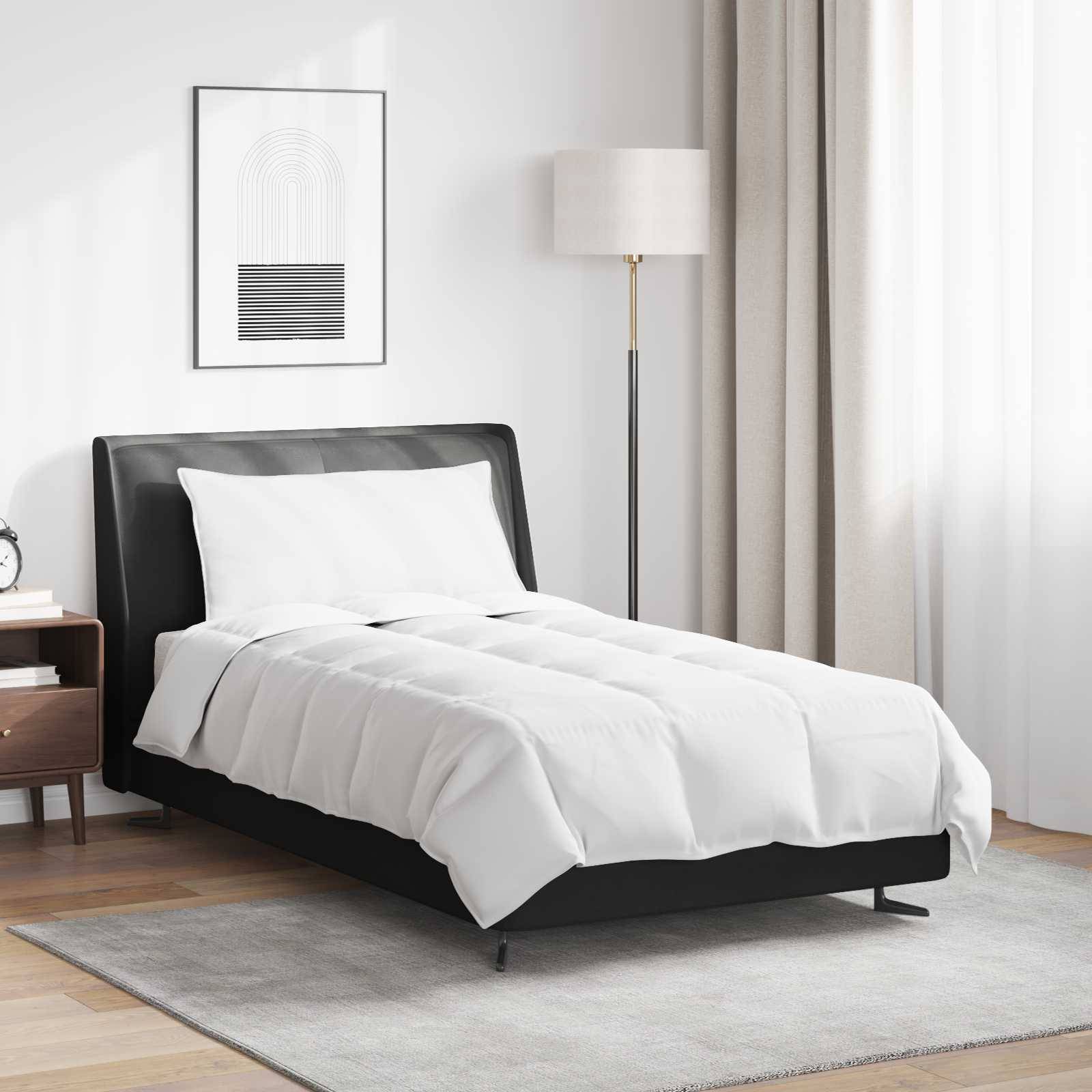 Ein modernes Schlafzimmer zeigt ein ordentlich gemachtes Bett mit einer weißen Bettdecke, einem gerahmten abstrakten Kunstwerk an der Wand und einer Stehlampe.