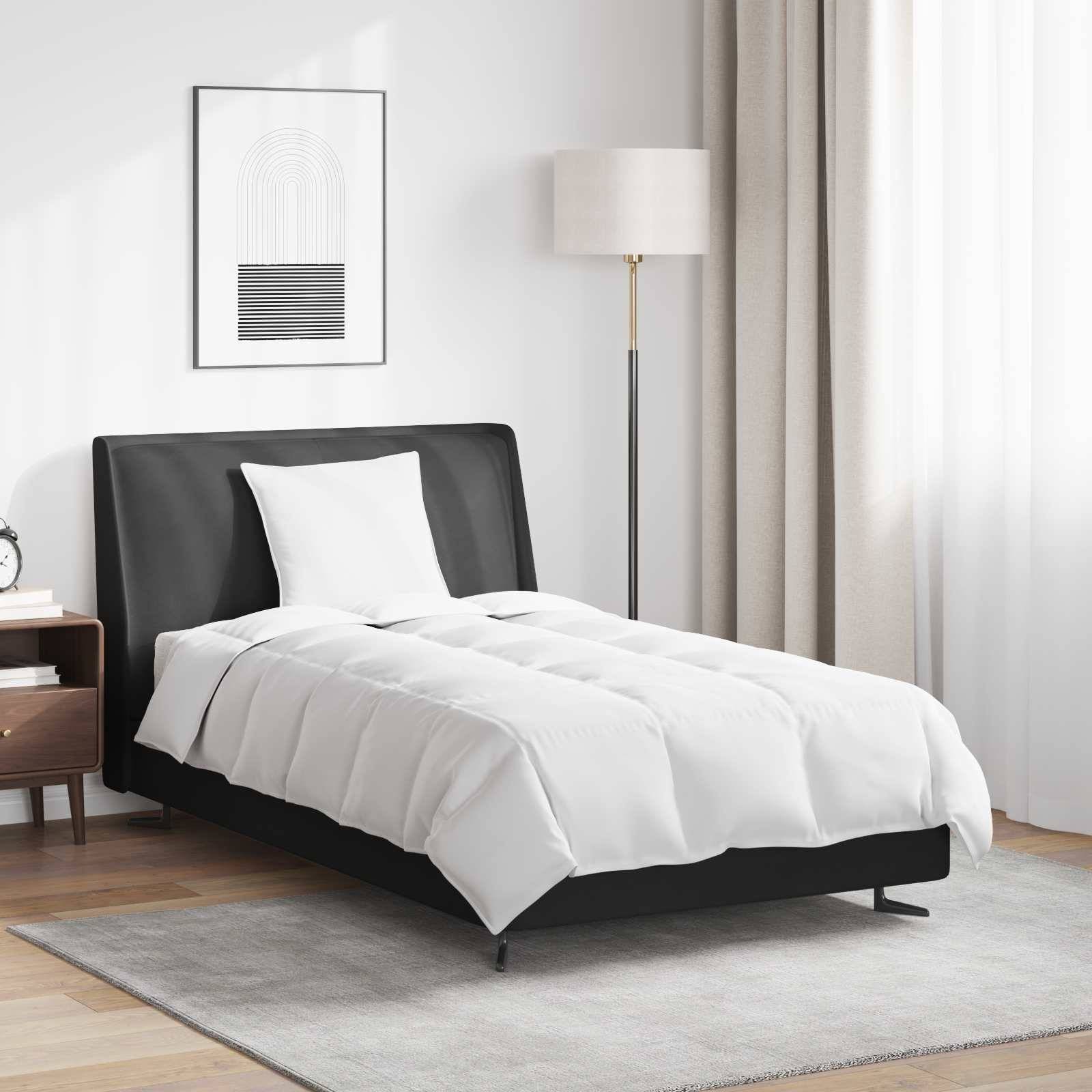 Ein modernes Schlafzimmer mit einem ordentlich gemachten Bett mit weißer Bettwäsche, einer hohen Stehlampe, einem Nachttisch mit Dekorationselementen und leichten Gardinen.