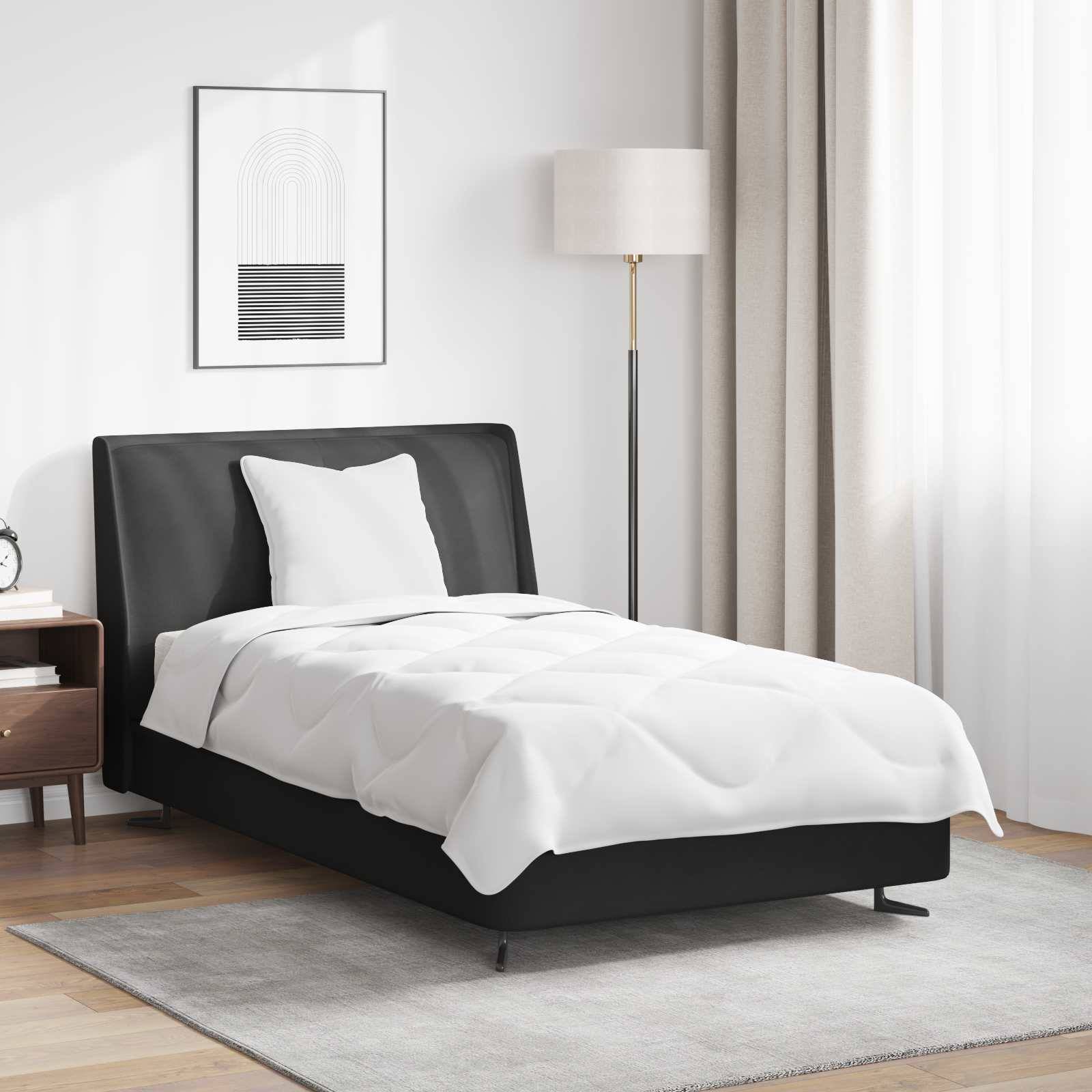 Ein ordentlich gemachtes Bett mit einer weißen Bettdecke und einem Kopfkissen in einem modernen Schlafzimmer; eine Stehlampe und abstrakte Kunstwerke zieren den Raum.