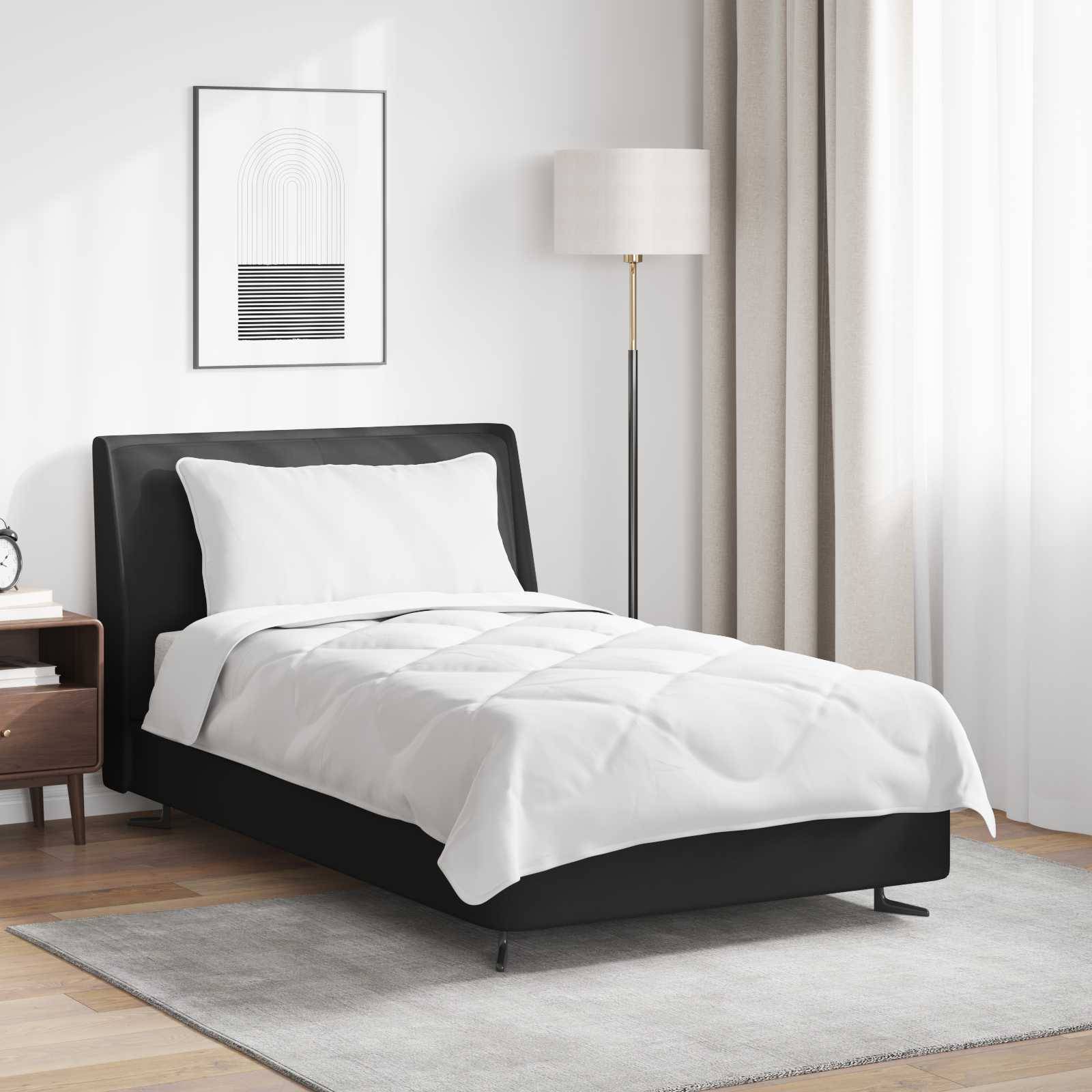 Ein modernes Schlafzimmer mit einem Einzelbett, schwarzem Kopfteil, weißer Bettdecke und minimalistischer Dekoration. Eine Stehlampe und ein gerahmtes Kunstwerk befinden sich im Hintergrund.