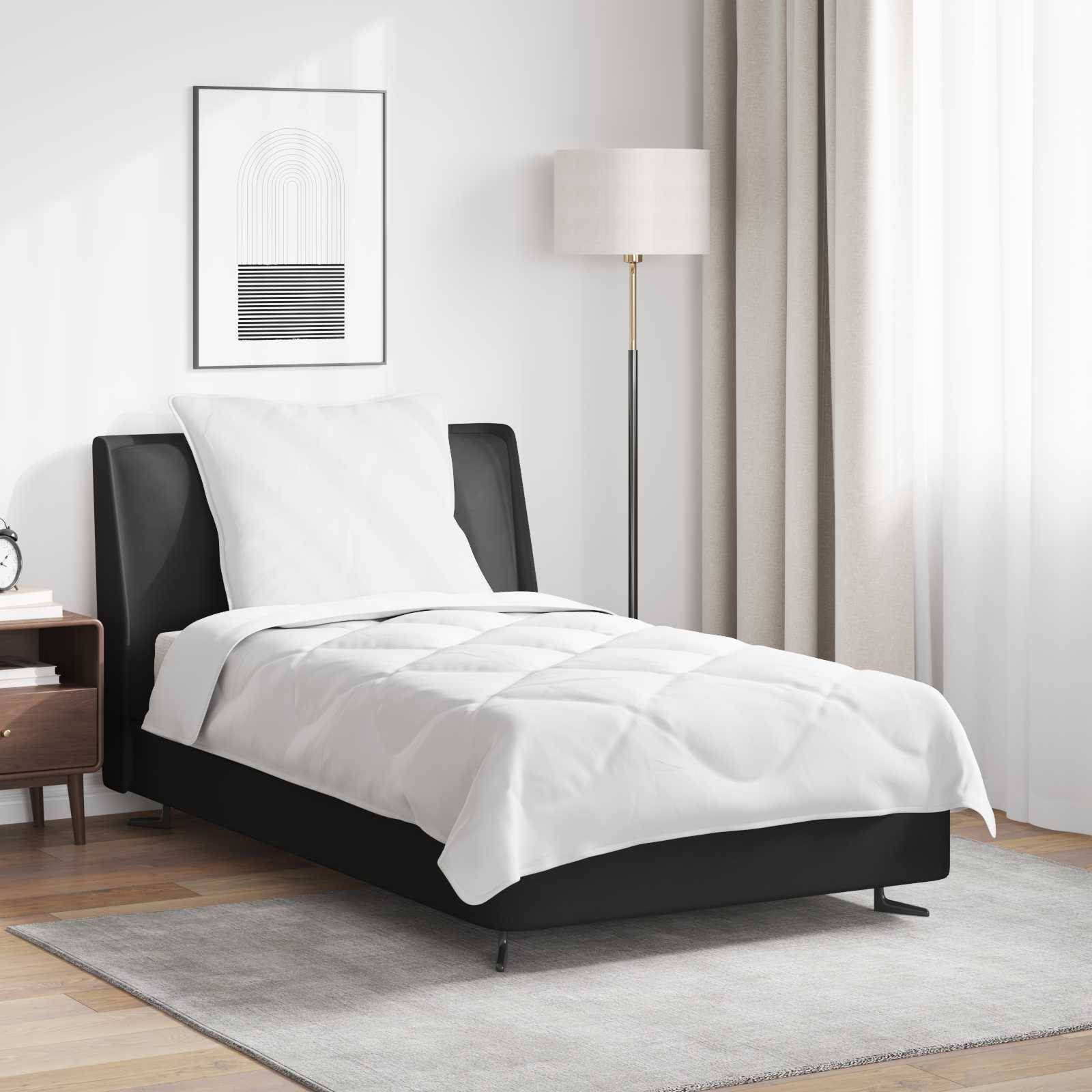 Ein sauber gemachtes Einzelbett mit weißer Bettwäsche in einem modernen Schlafzimmer, ausgestattet mit einem schwarzen Rahmen, einer hohen Lampe, einem Nachttisch und minimalistischer Dekoration.