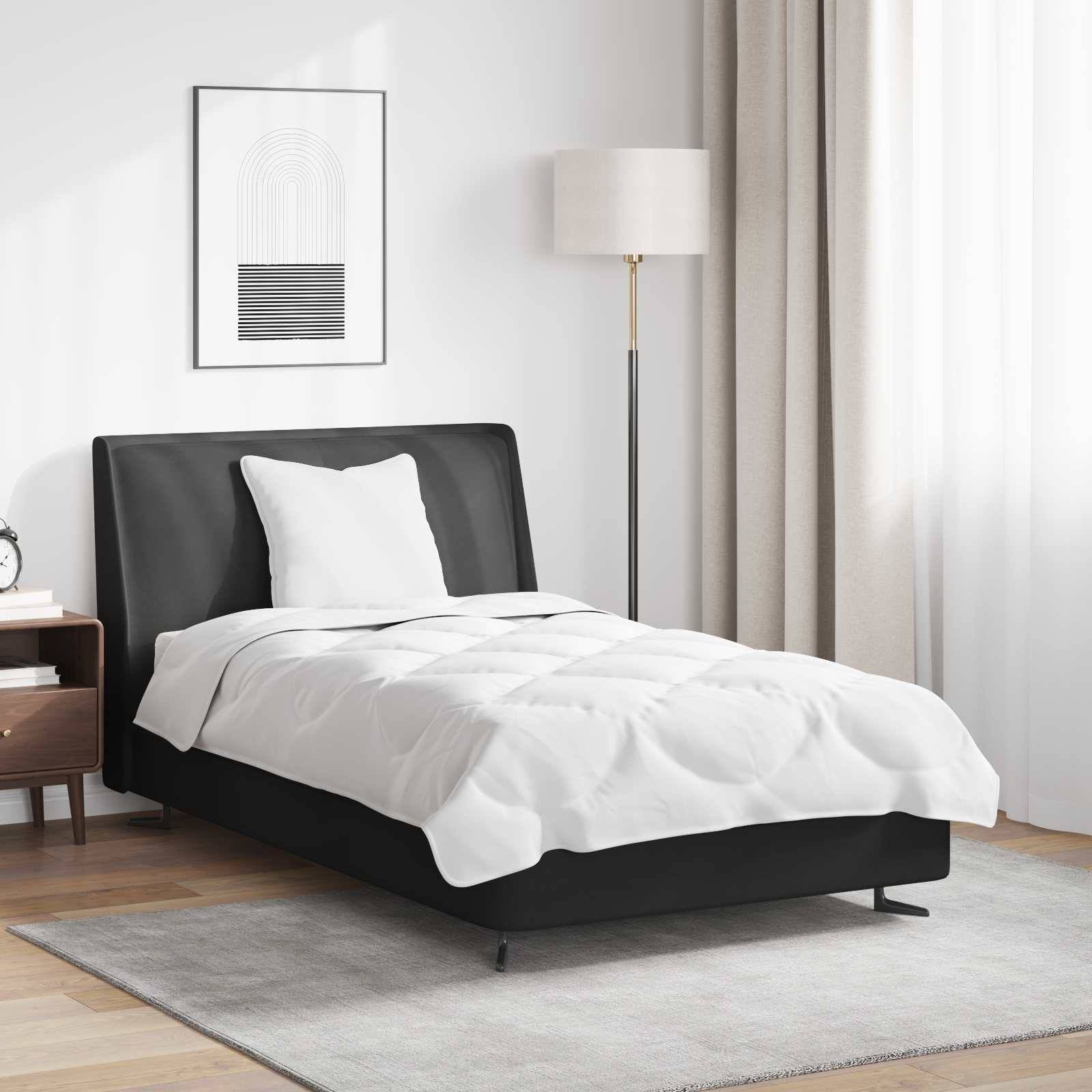 Ein ordentlich gemachtes Bett mit weißen Laken und einem schwarzen Kopfteil, flankiert von einem Nachttisch und einer Stehlampe, in einer minimalistischen Schlafzimmerumgebung.