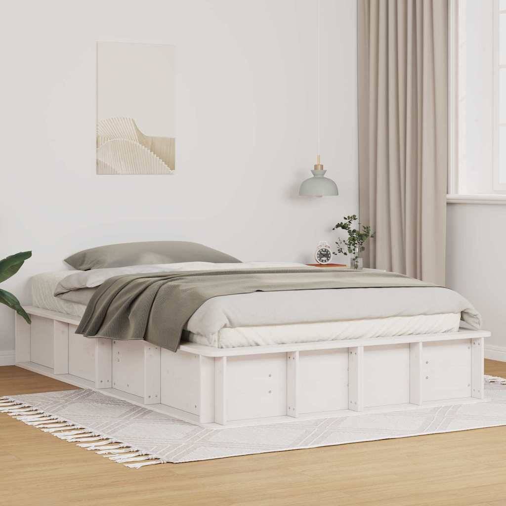 Ein minimalistisches Schlafzimmer mit einem niedrigen weißen Plattformbett, grauen Bettwaren und einem Teppich auf Holzdielen. Eine Topfpflanze und ein Vorhang ergänzen die Dekoration.