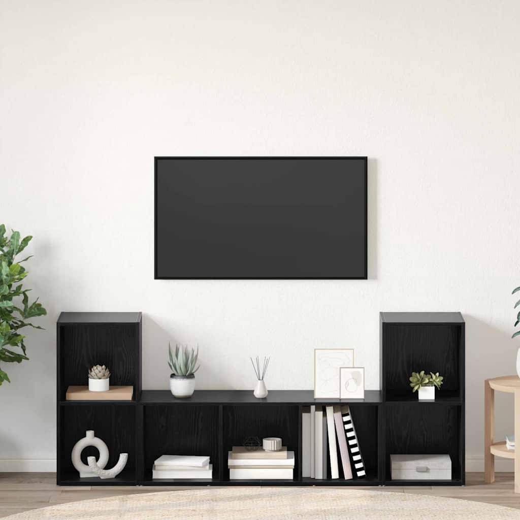 Ein minimalistisches Wohnzimmer mit einer an der Wand montierten TV und einem schwarzen Regalsystem darunter. Das Regal ist mit Dekoartikeln, Büchern und Pflanzen bestückt.