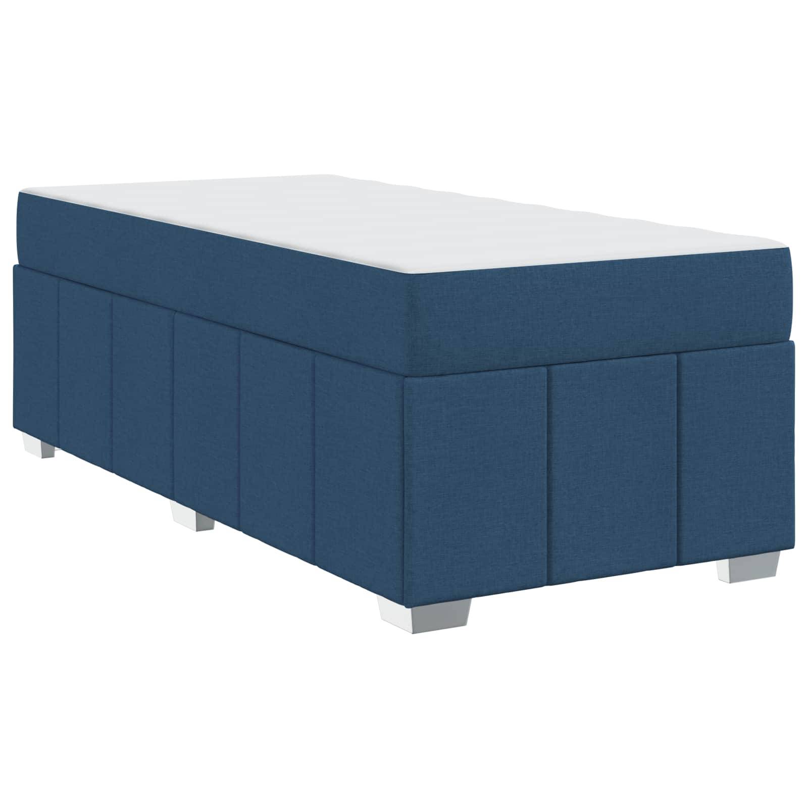 Eine blaue gepolsterte Bettbasis mit einem einfachen, modernen Design, das rechteckige Paneele und kurze, quadratische Beine aufweist. Kein Kopfteil ist zu sehen.