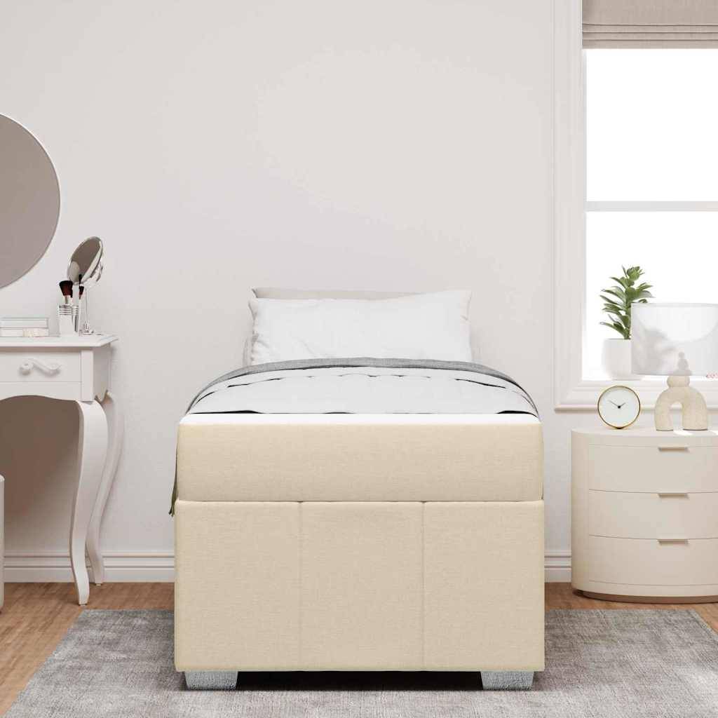 Ein ordentlich gemachtes Bett mit einem beigen gepolsterten Rahmen in einem minimalistischen Schlafzimmer. Ein weißer Schminktisch und ein runder Spiegel befinden sich links.