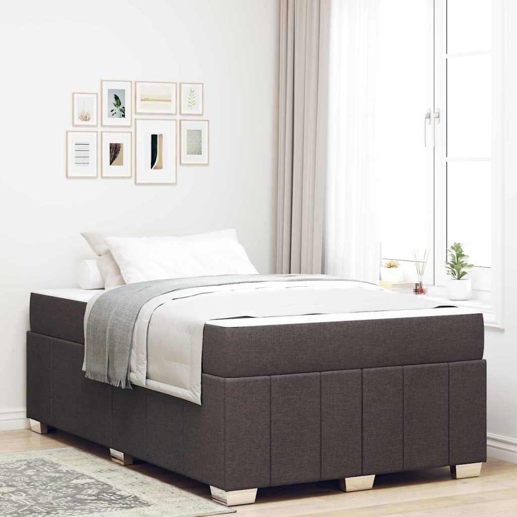 Ein modernes Schlafzimmer zeigt ein dunkel gepolstertes Bett mit weißer Bettwäsche und einer hellgrauen Decke. Ein Fenster mit leichten Vorhängen erhellt den Raum.
