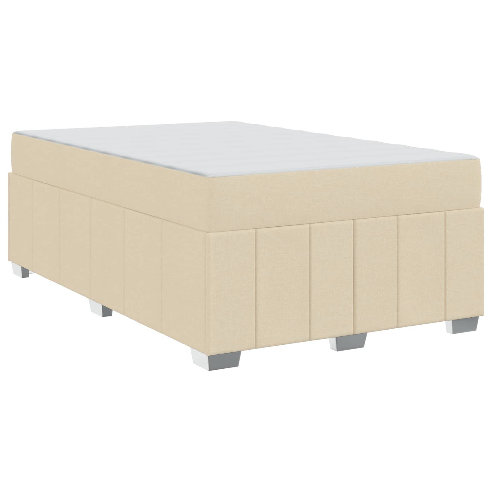 Ein beige gepolsterter Boxspringrahmen mit einer flachen weißen Oberfläche und silbernen Beinen, geeignet zur Unterstützung einer Matratze in einem Schlafzimmerambiente.
