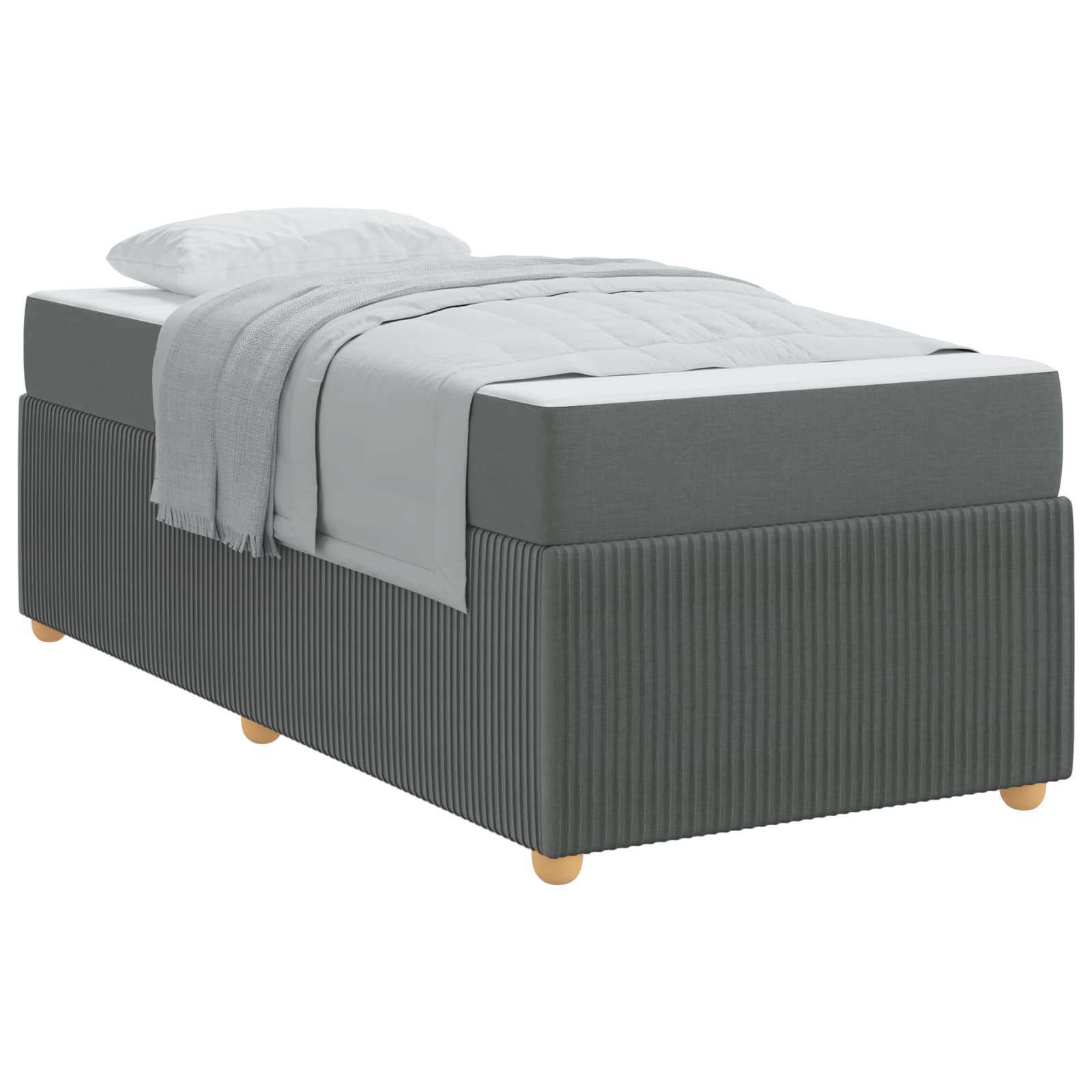 Ein graues gepolstertes Einzelbett mit einer weißen Matratze, einem Kissen und einer hellgrauen Decke, die ordentlich darauf drapiert ist.