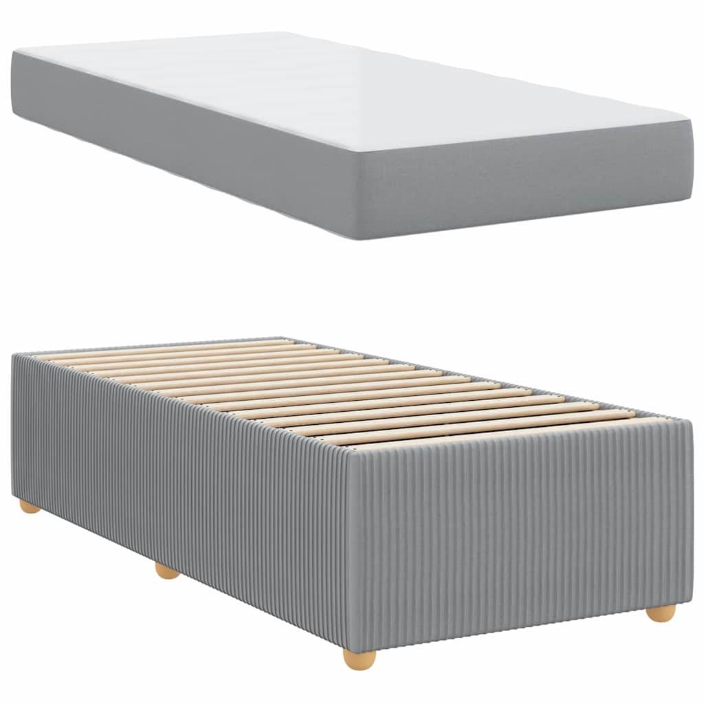 Ein grauer Bettrahmen mit Holzlatten und runden Beinen wird in minimalistischem Stil mit einer passenden grauen Matratze kombiniert.
