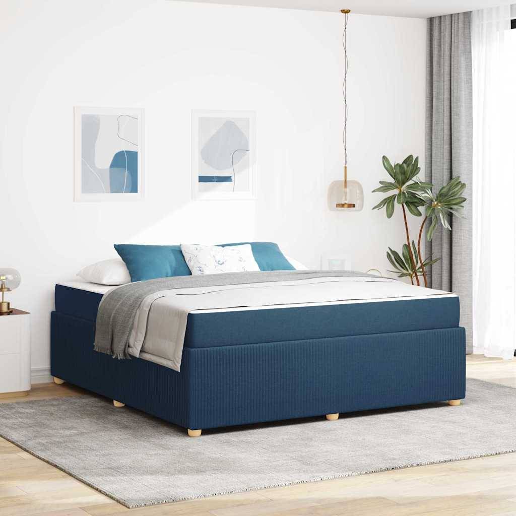 Ein modernes Schlafzimmer zeigt ein blau gepolstertes Bett mit weiß-grauer Bettwäsche, eine Topfpflanze, abstrakte Wandkunst und sanfte Beleuchtung.