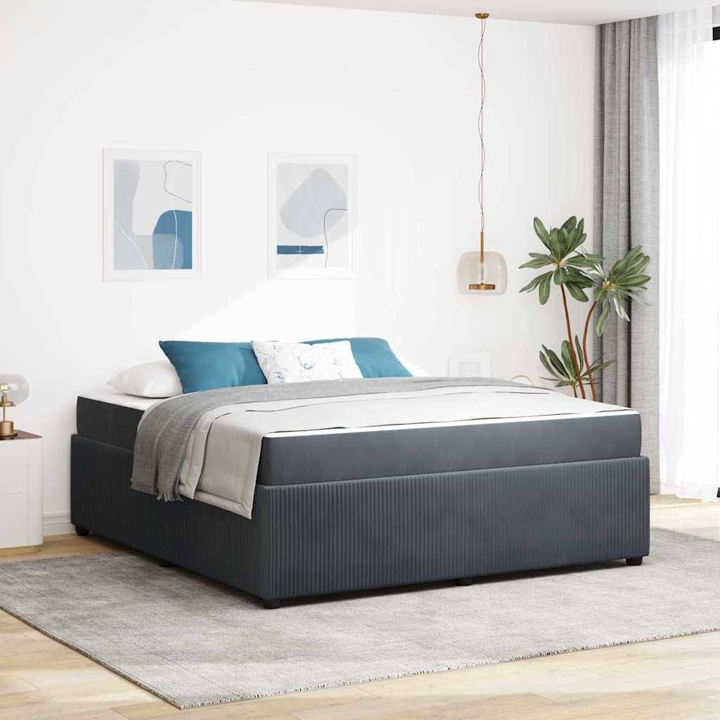 Ein modernes Schlafzimmer mit einem ordentlich gemachten Bett, das weiße und graue Bettwäsche trägt. Eine Pflanze steht am Fenster; zwei abstrakte Gemälde hängen über dem Bett.