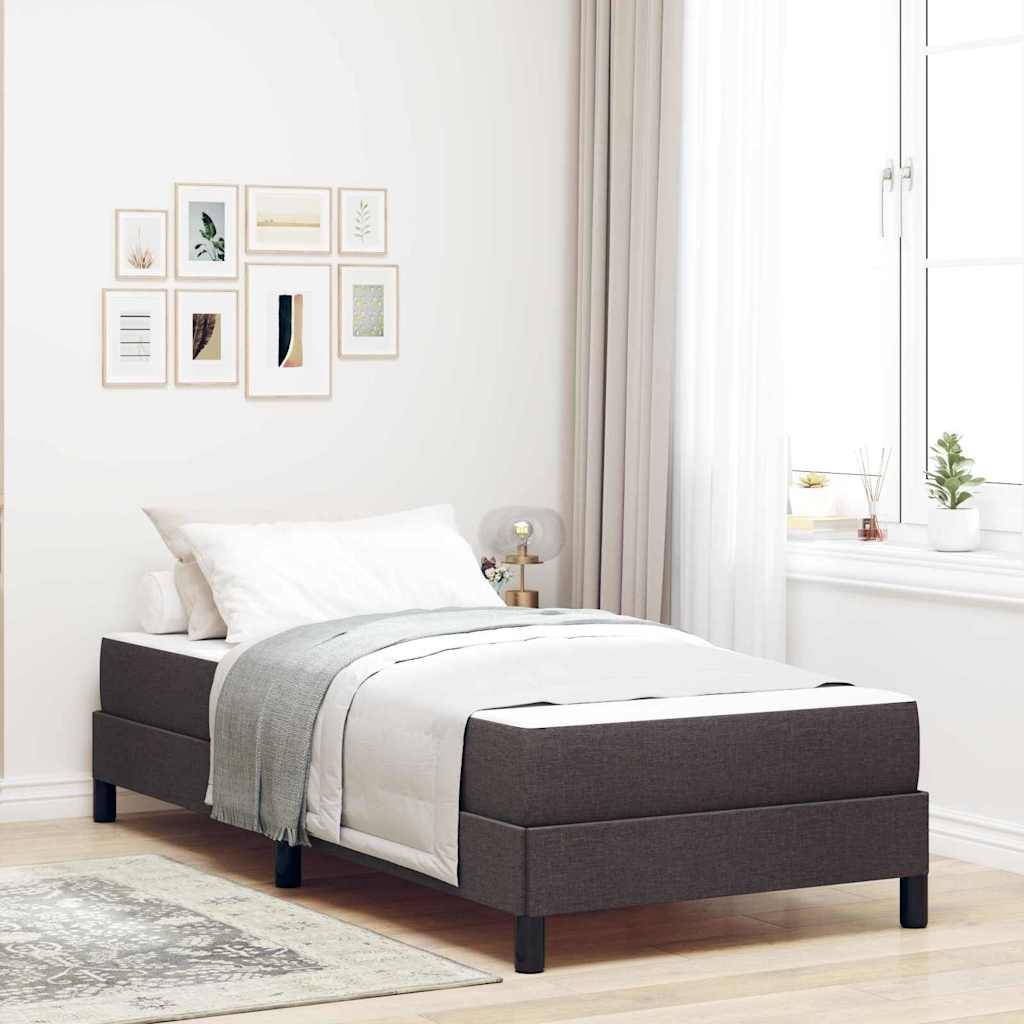 Ein sauber bezogenes Bett mit grauer Bettwäsche steht in einem hellen Raum. Ein großes Fenster und gerahmte Kunstwerke an der Wand schaffen eine gemütliche, moderne Atmosphäre.