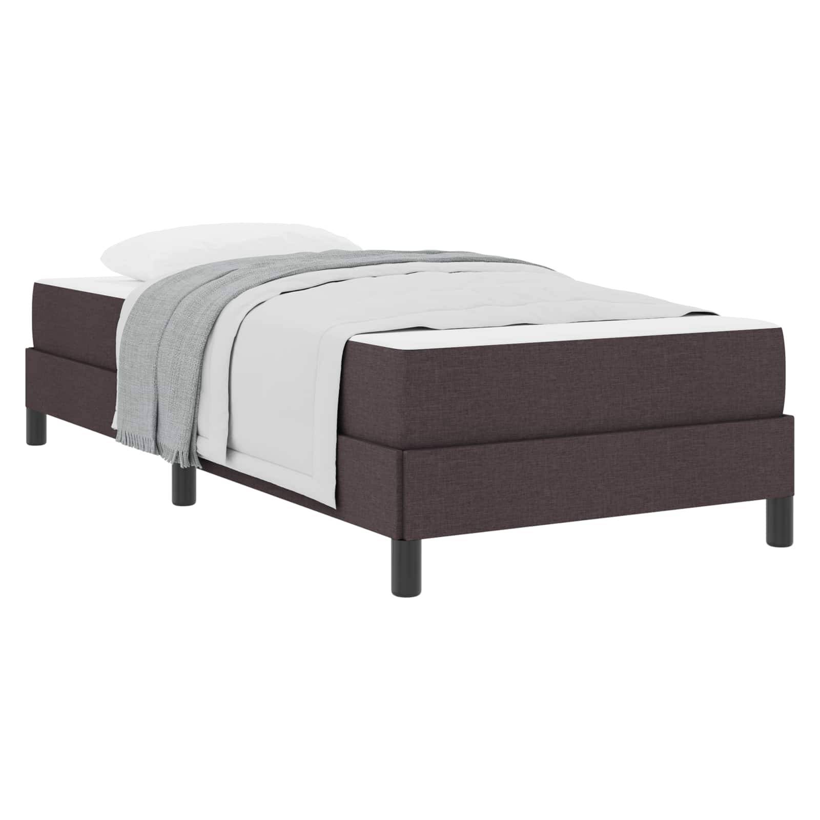Ein Einzelbett mit einem dunklen Rahmen, weißer Bettwäsche und einer grauen Decke, die seitlich herunterhängt.