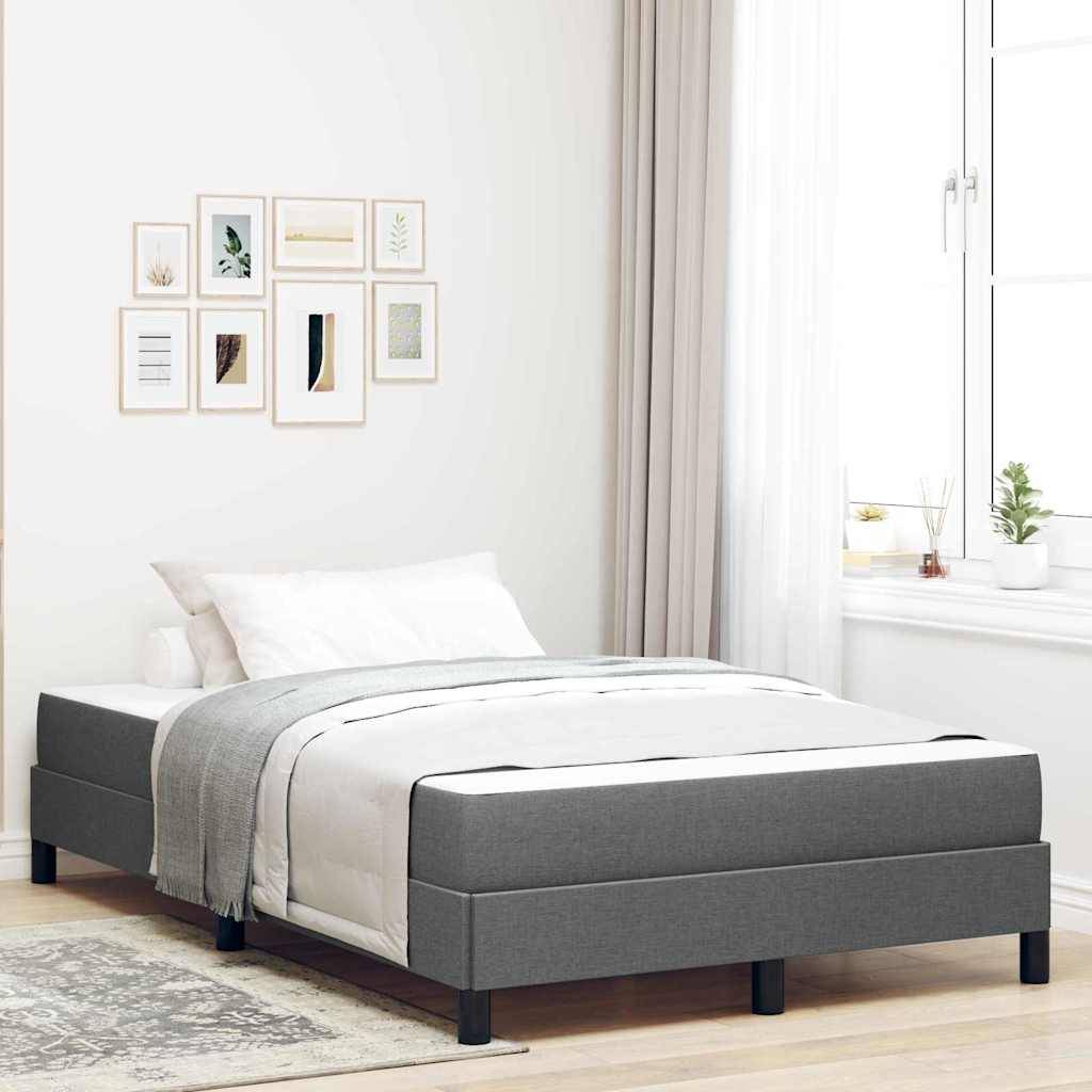 Ein modernes Schlafzimmer mit einem grauen Bettgestell und weißer Bettwäsche, akzentuiert durch eine Reihe von minimalistischen gerahmten Kunstwerken an der Wand und einem sonnendurchfluteten Fenster.