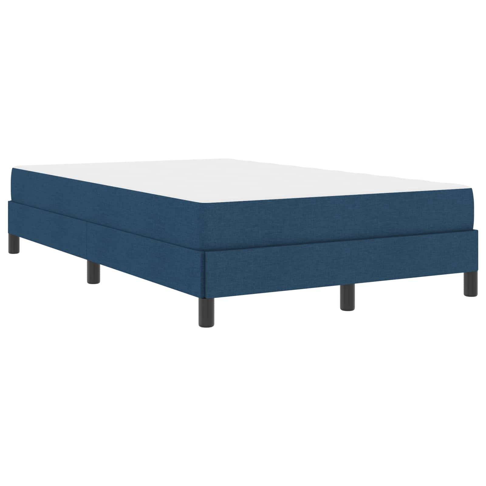 Ein blau gepolsterter Bettrahmen mit schwarzen Beinen, von einem Winkel aus betrachtet. Der Rahmen hat ein schlichtes, modernes Design mit einer Matratze darauf.
